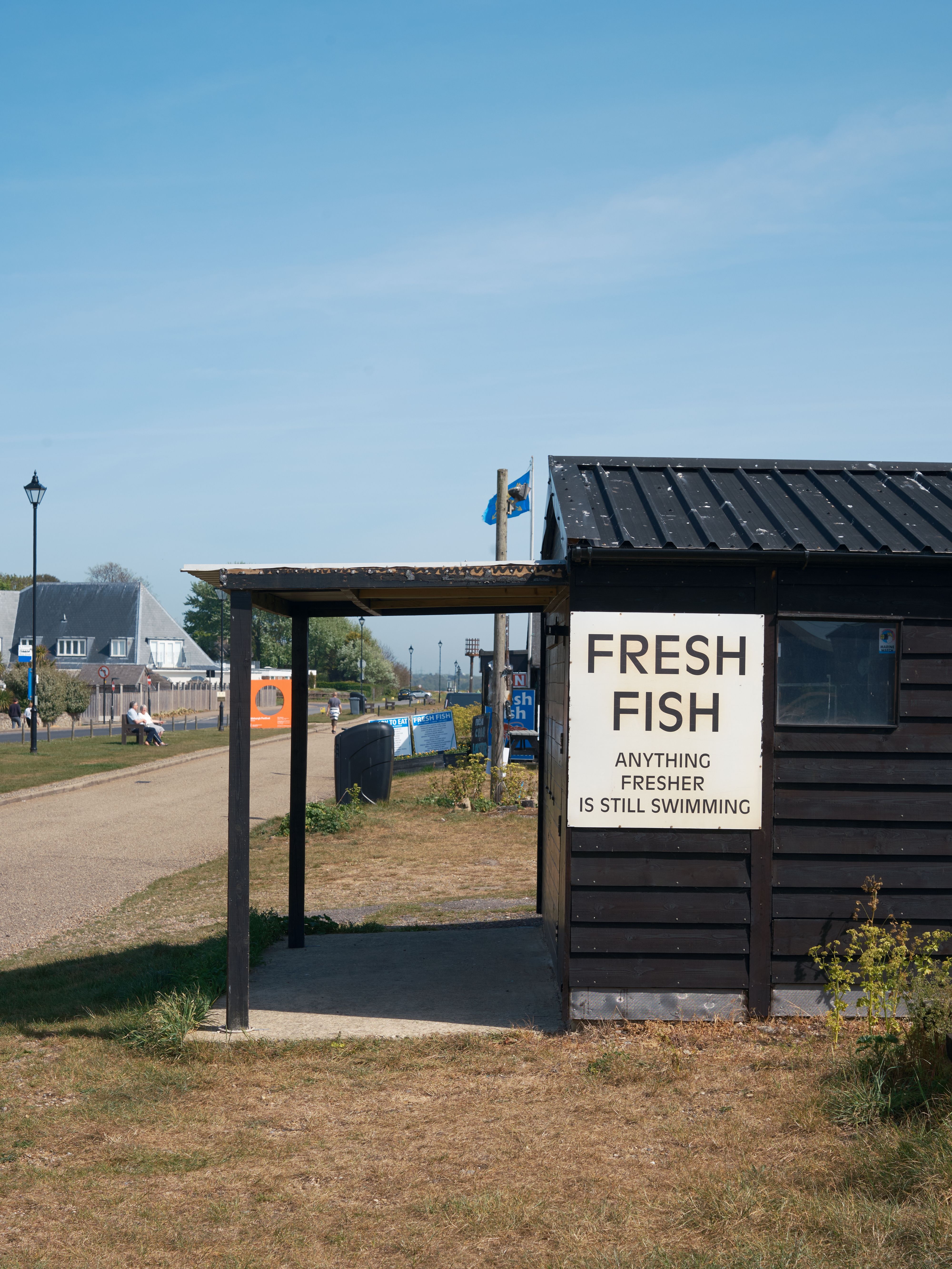 Fish shack with a sign reading "fresh fish, anything fresher is still swimming!"