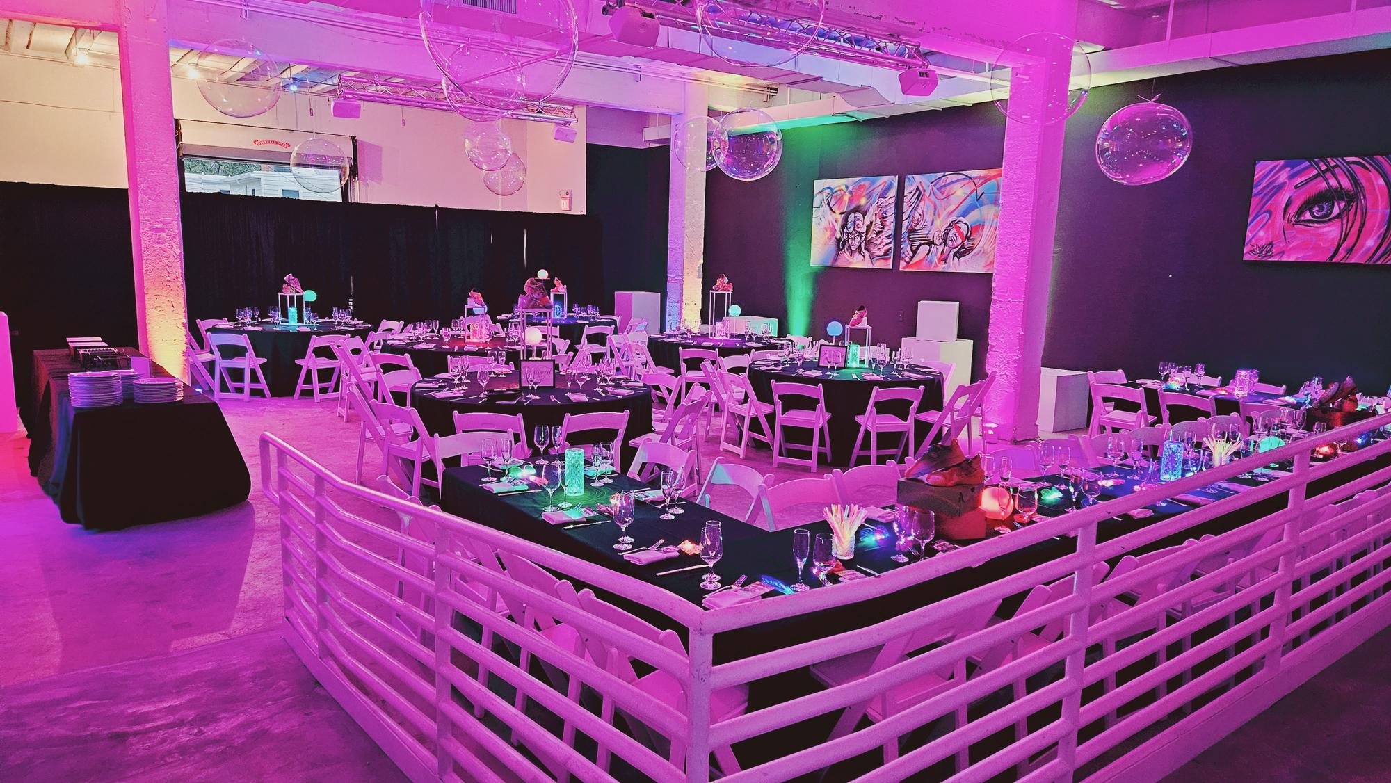 A neon-lit seated dinner in the Event Hall
