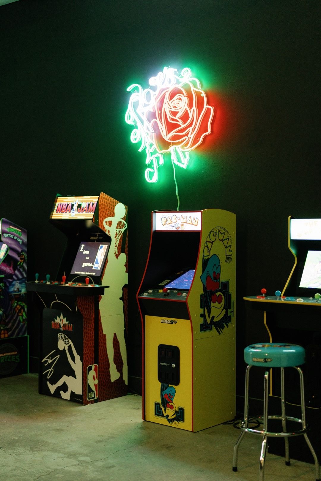 Arcade cabinets and a neon rose sign