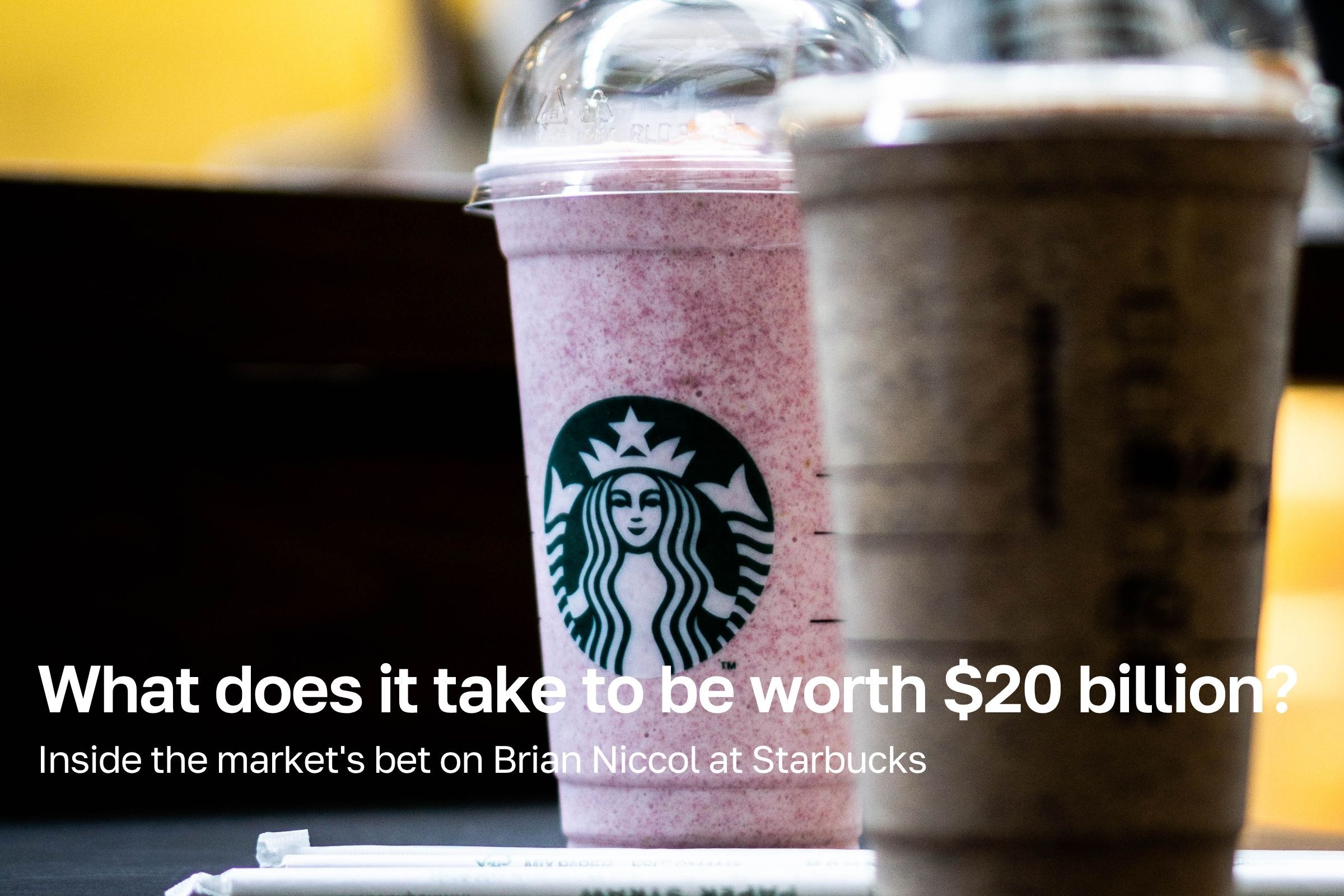 Two Starbucks Frappuccino cups on a cafe counter, the siren logo facing forward, beneath the article title.