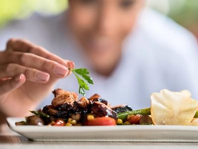 a chef puts the finishing touch on a dish
