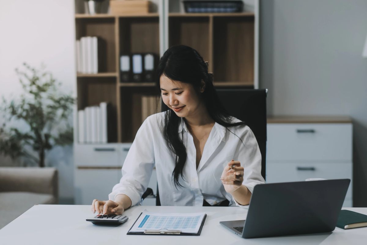 woman wearing a white shirt using a calculator