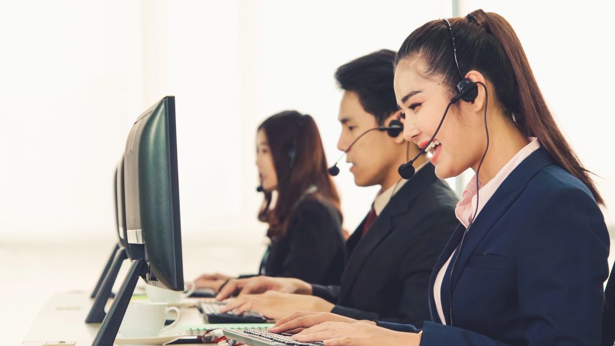 three call center agents on BPO workstation wearing headsets