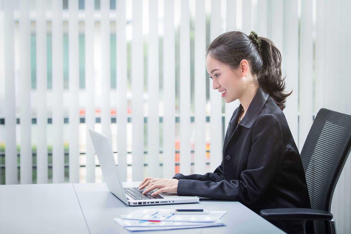 female office worker typing on laptop