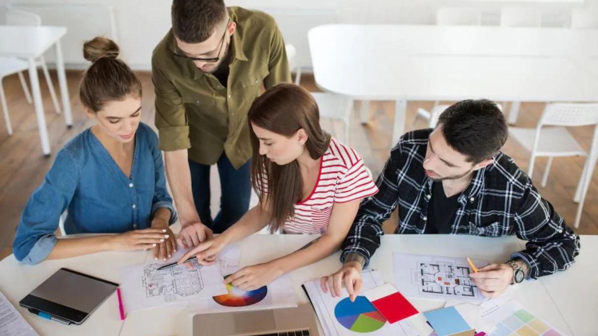 four people discussing a floor plan