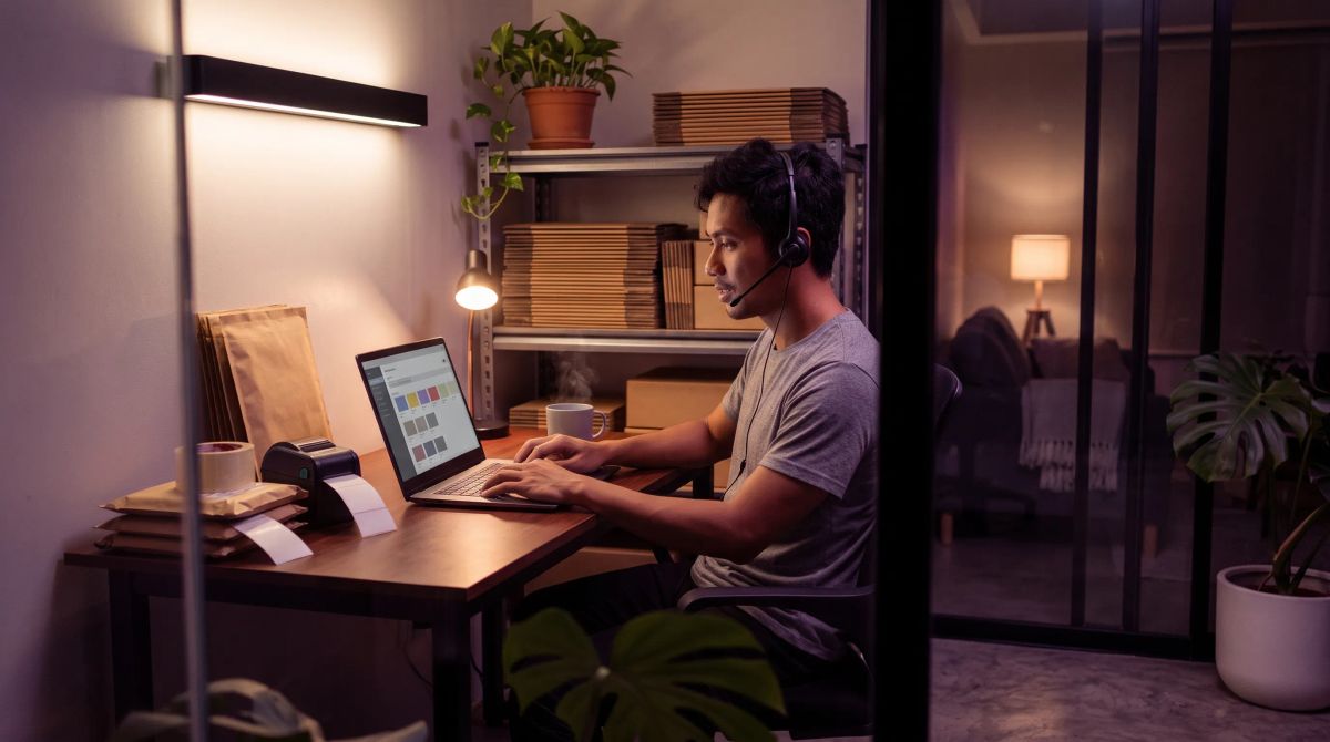 Filipino agent handles outsource ecommerce customer service orders on a laptop from his home desk during a night shift in Manila