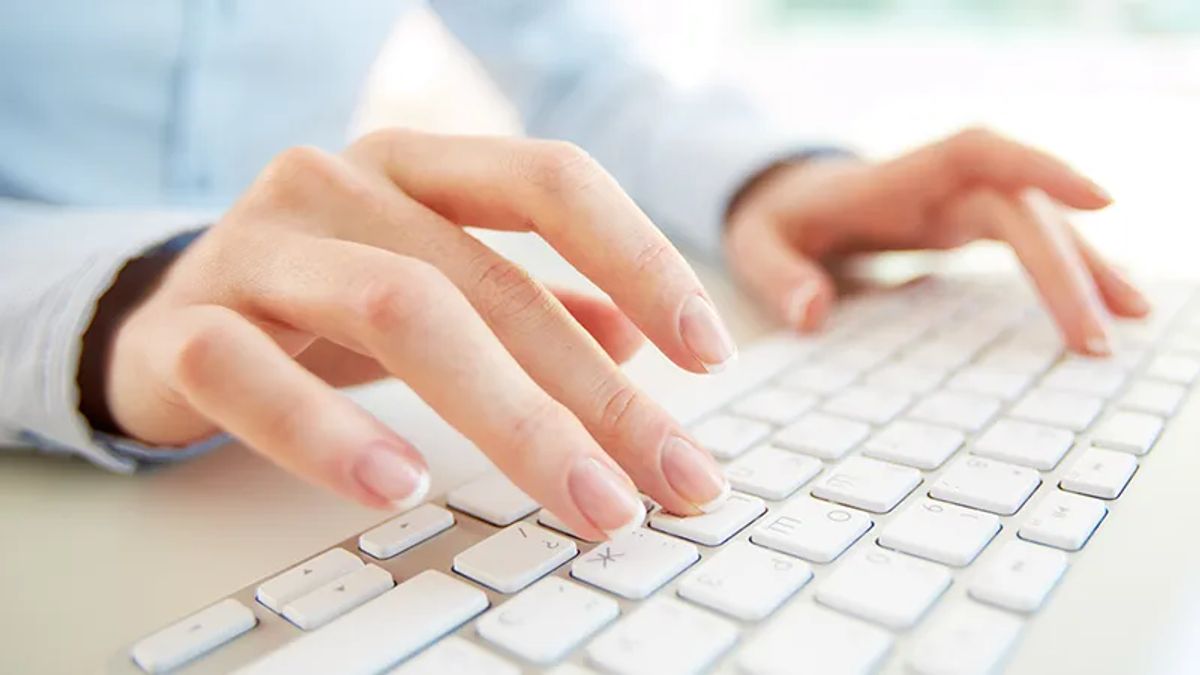 two hands typing on keyboard