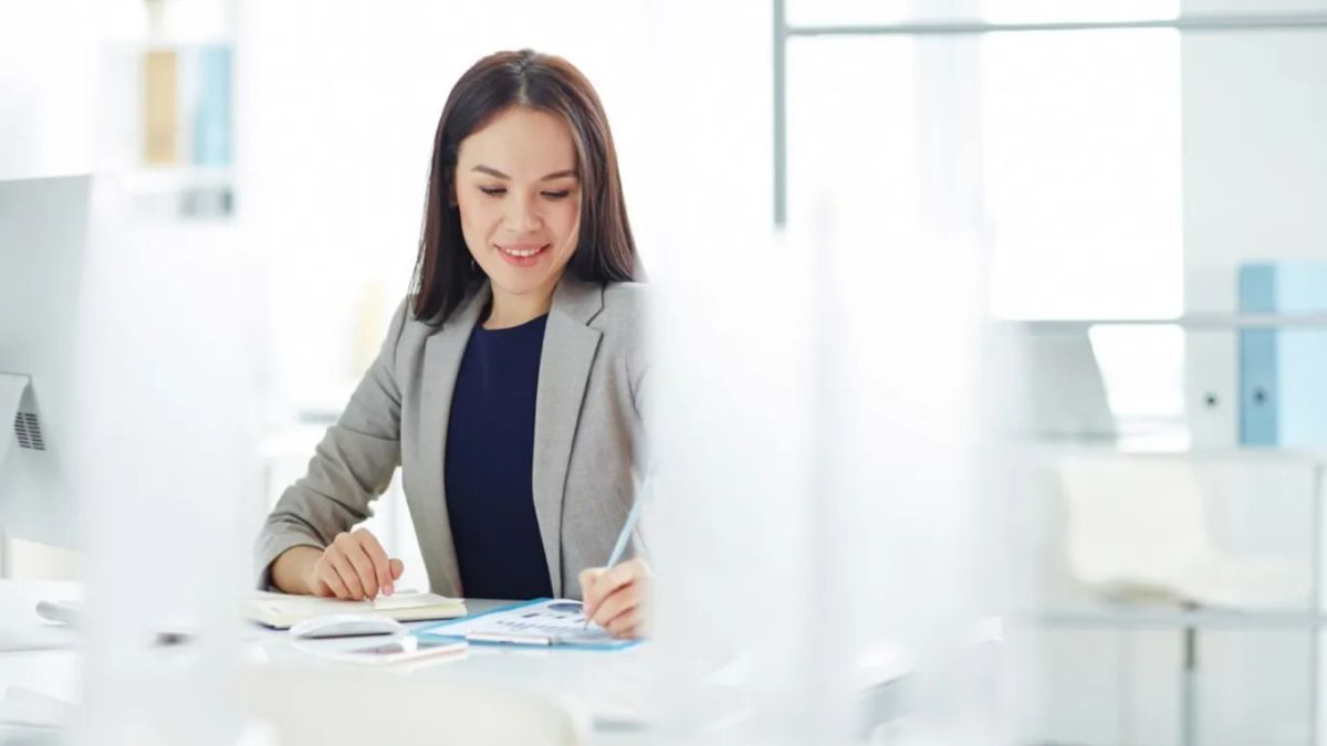 woman with gray blazer writing something down