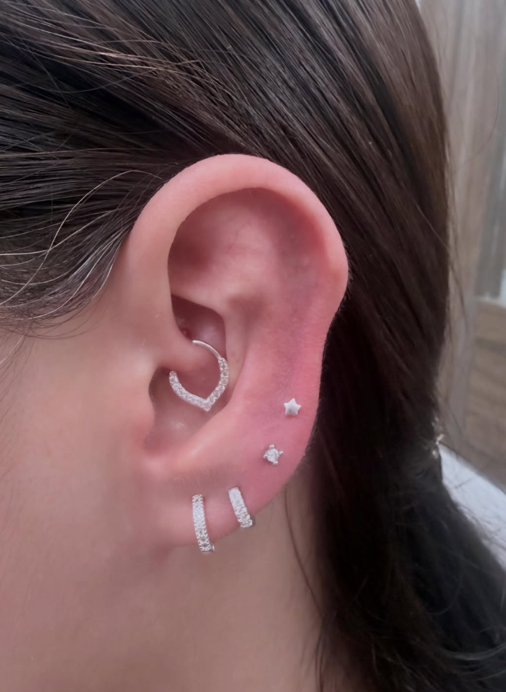 Perforación de oreja realizada con aros plateados