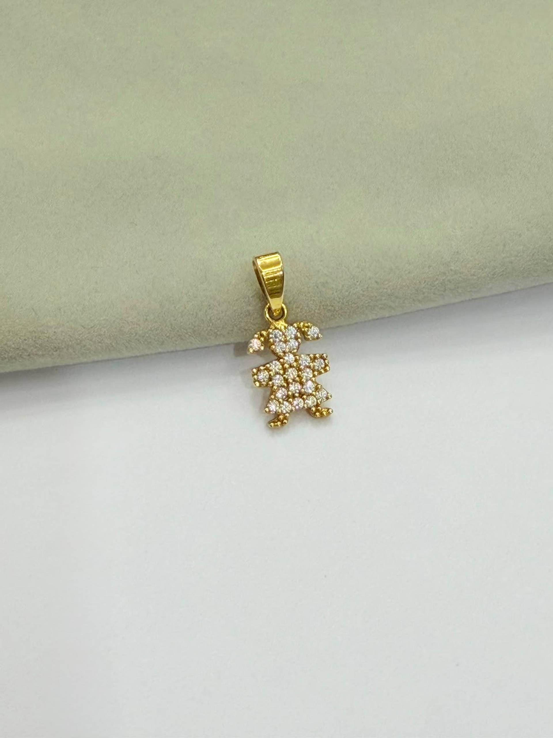 Dije Niña con vestido de piedritas tachonadas de circón blanco, de oro 18 kilates