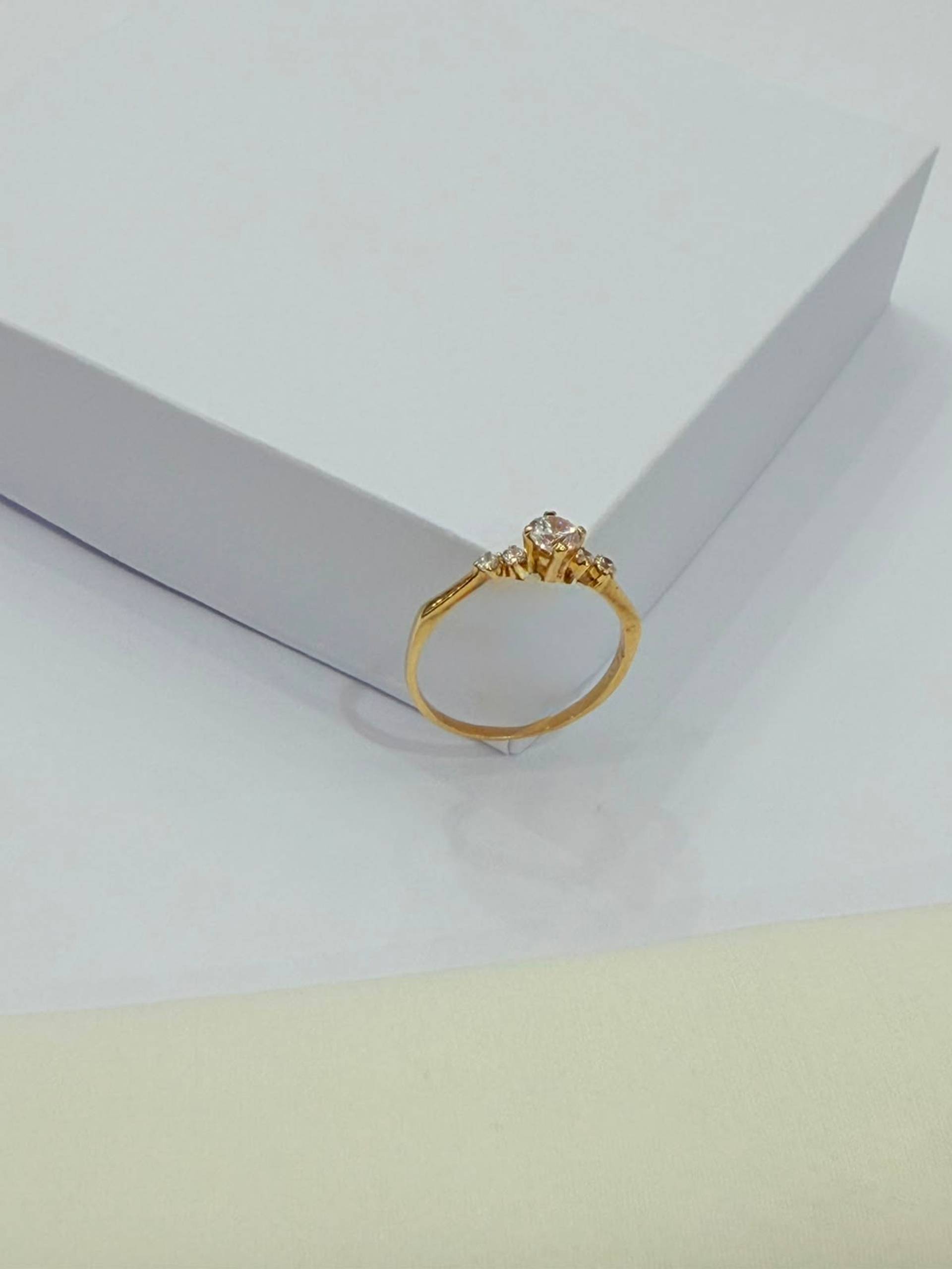 Anillo de oro 18K con detalle entrelazado y circonias