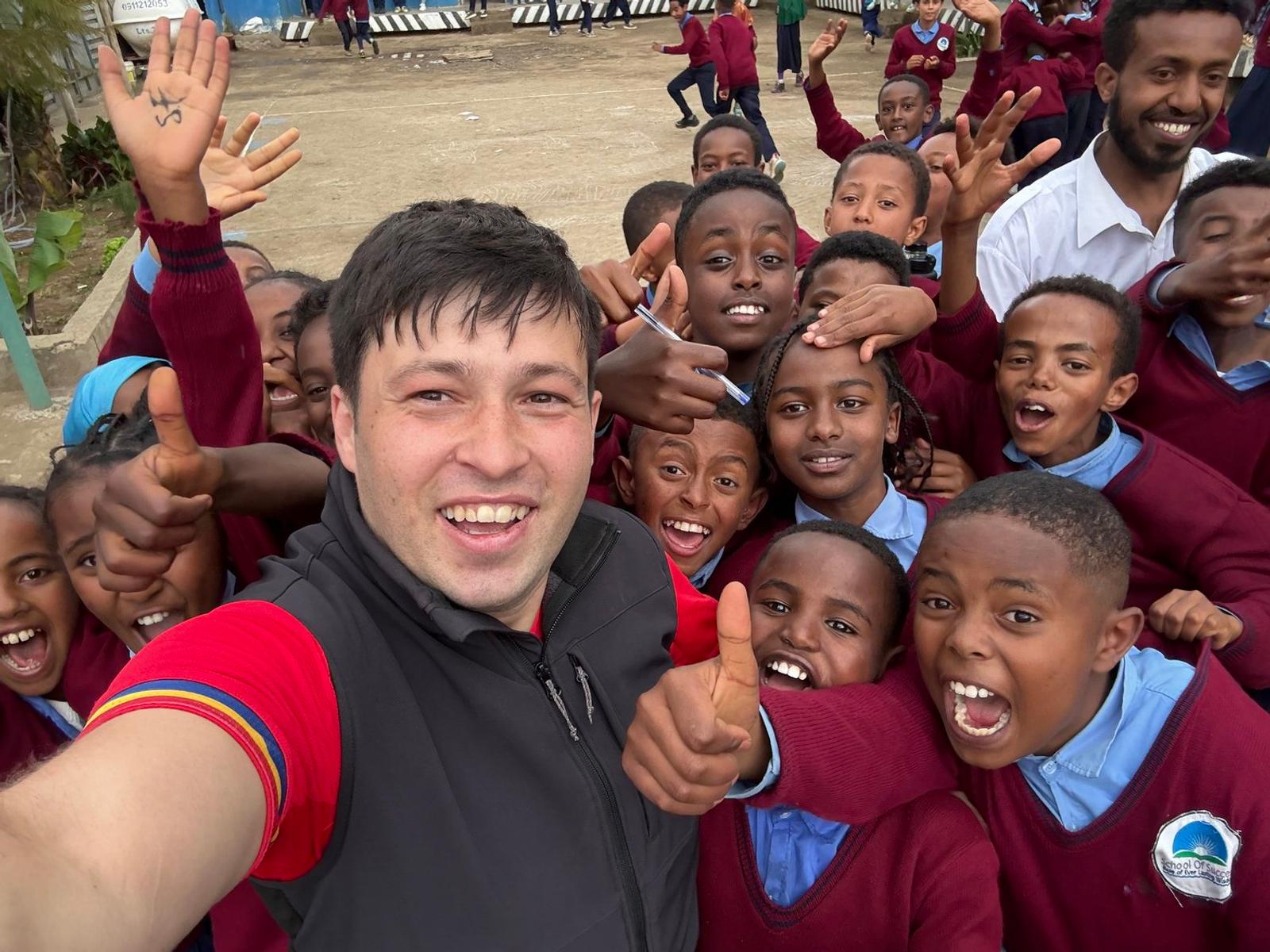 Stefan and children sharing a selfie in Ethiopia