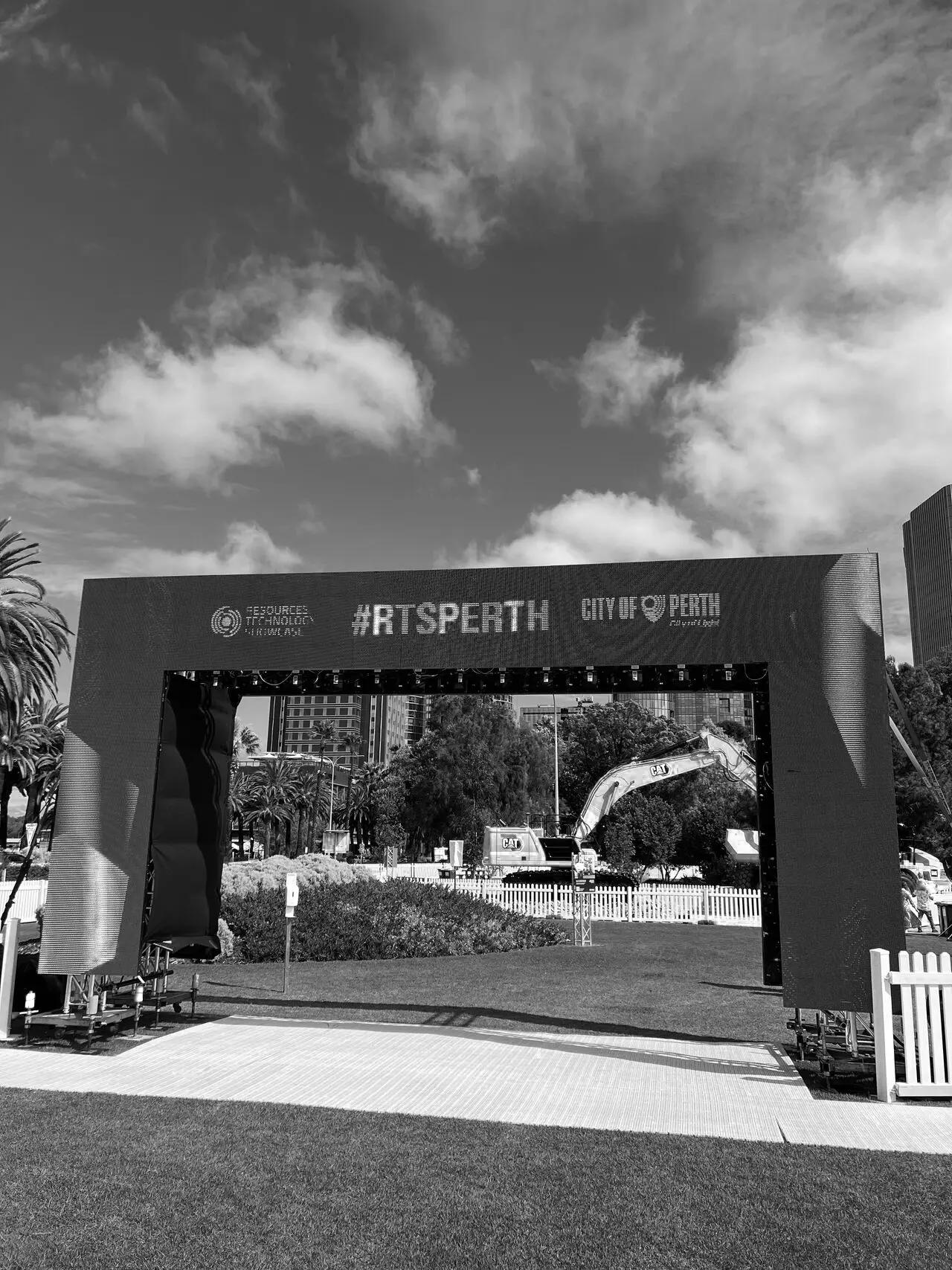 A branded event arch spanning a path through a Perth park.