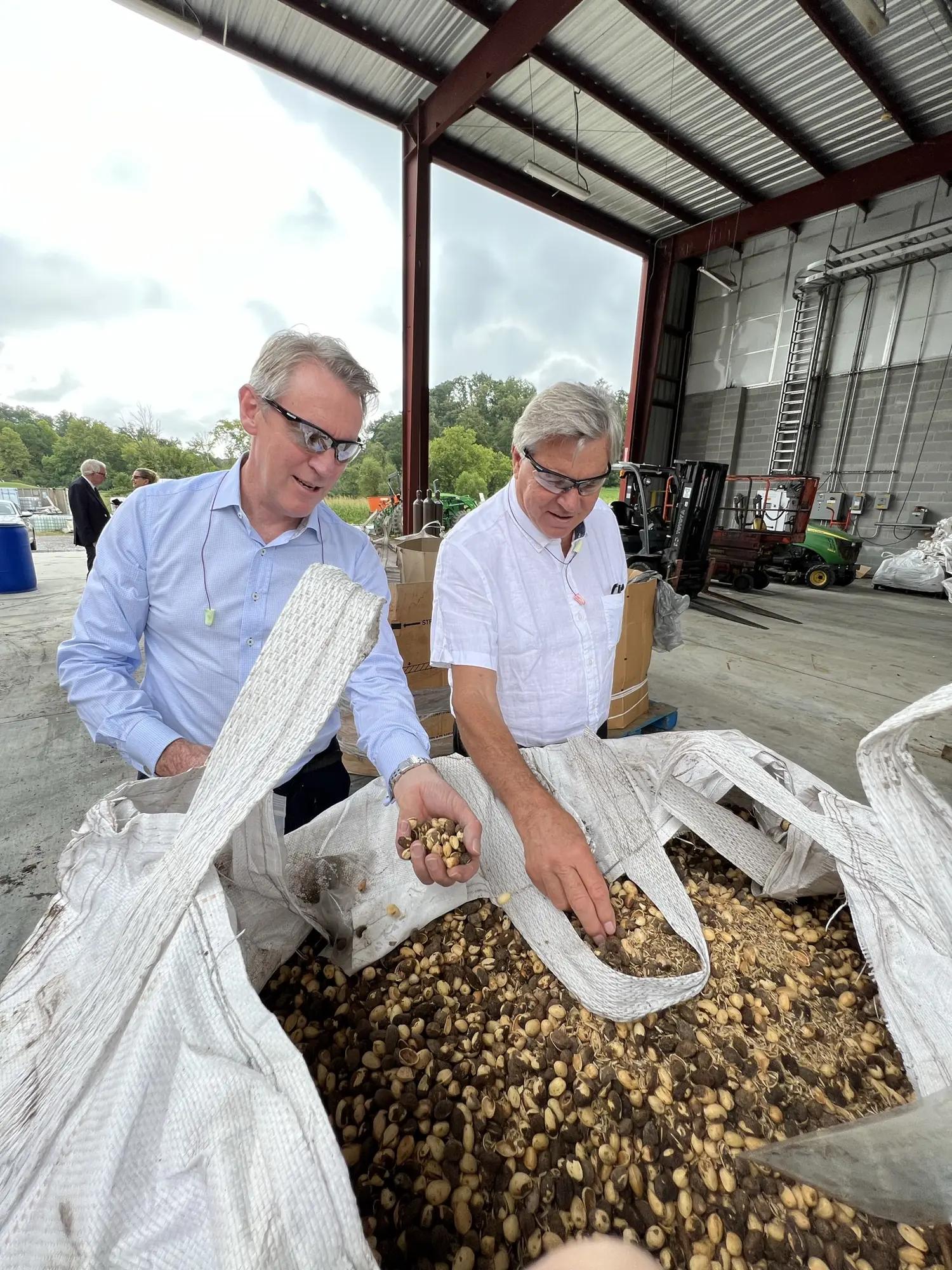 Two FutureEnergy representatives inspecting feedstock in a regional processing shed.