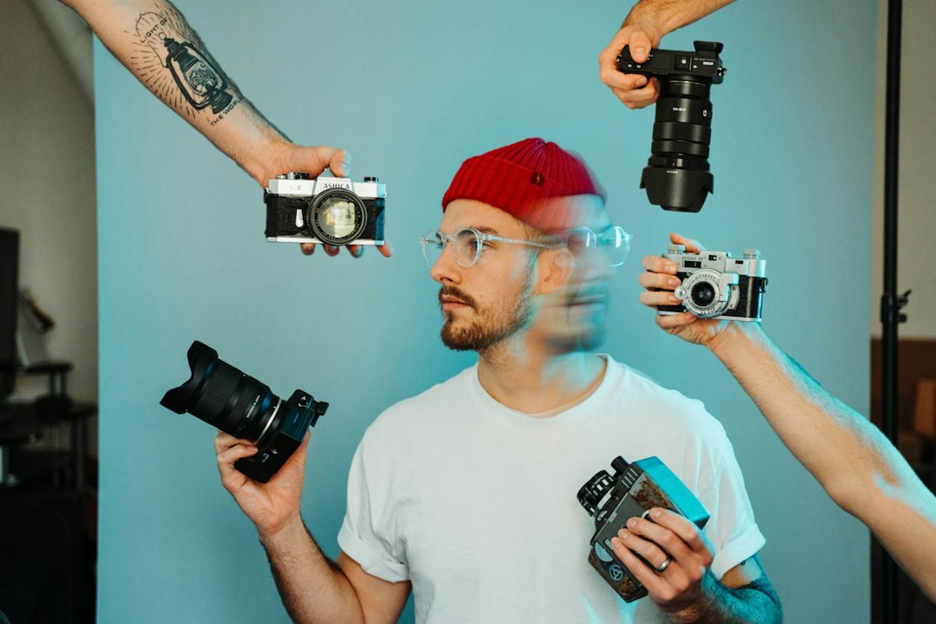 Fotografer dikelilingi beberapa kamera, gambaran SEO dan produksi visual dalam satu tim