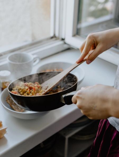 Person holding black frying pan