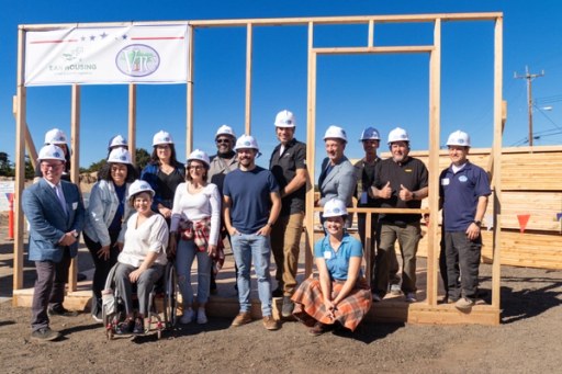 Community members at the Lightfighter Village wall raising