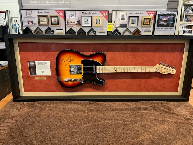 The autographed sunburst guitar Nathan won at the 2024 Hope for Heroes Gala, mounted in a shadow-box frame
