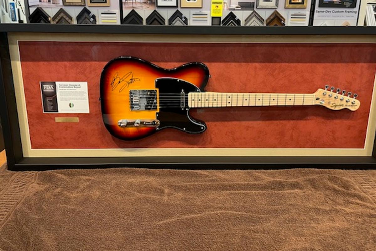 The autographed sunburst guitar Nathan won at the 2024 Hope for Heroes Gala, mounted in a shadow-box frame