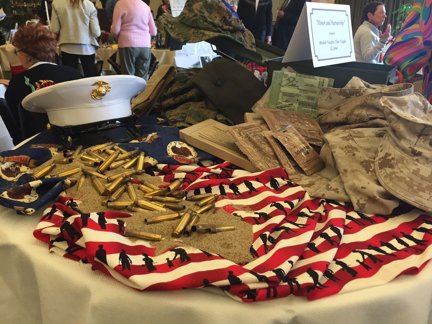 A display of Marine Corps uniforms, a dress cap and a Stars-and-Stripes cloth honoring Veterans at a VTC event