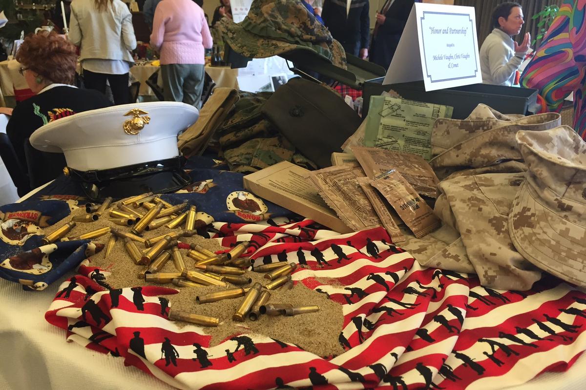 A display of Marine Corps uniforms, a dress cap and a Stars-and-Stripes cloth honoring Veterans at a VTC event