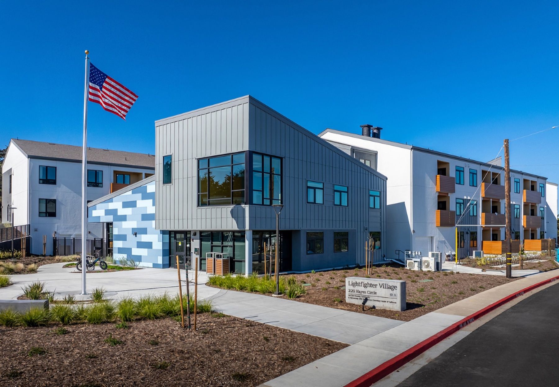 The entrance of Lightfighter Village with the American flag flying