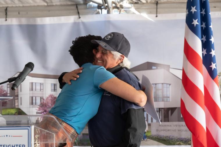 Community members at the Lightfighter Village wall raising