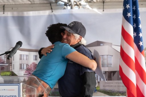 Community members at the Lightfighter Village wall raising