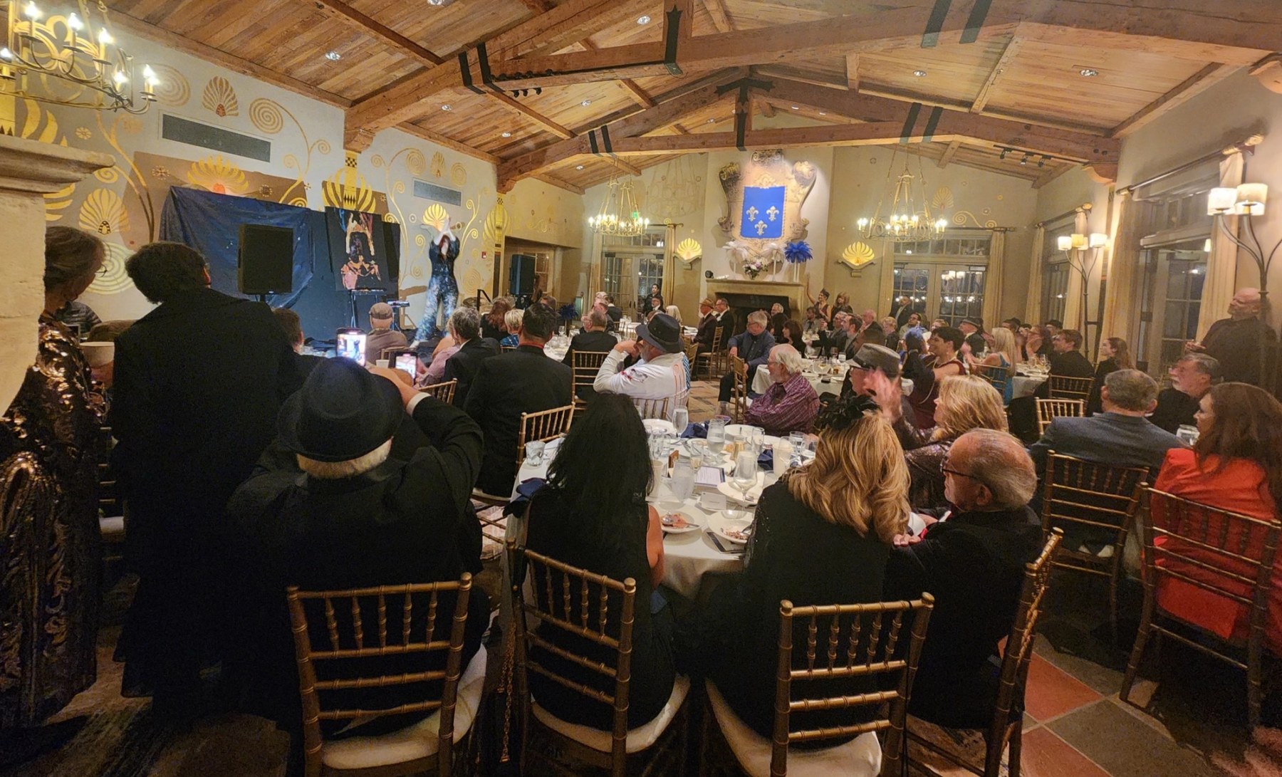 A live painter performs on stage in the gold-muraled ballroom at the Hope for Heroes Gala