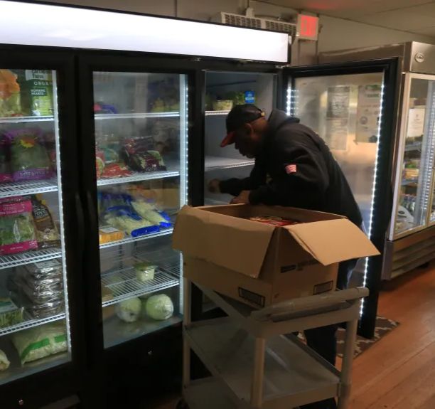 Pantry Manager Amos Johnson stocks the fridge at the Veterans Transition Center