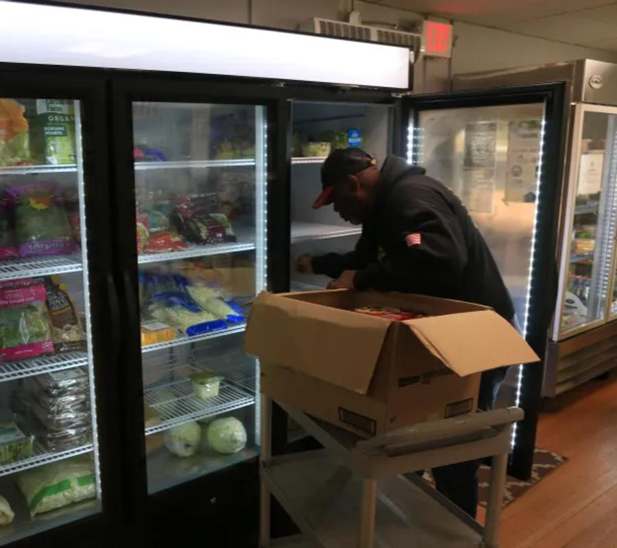 Pantry Manager Amos Johnson stocks the fridge at the Veterans Transition Center