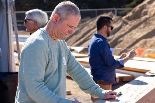 Community members at the Lightfighter Village wall raising