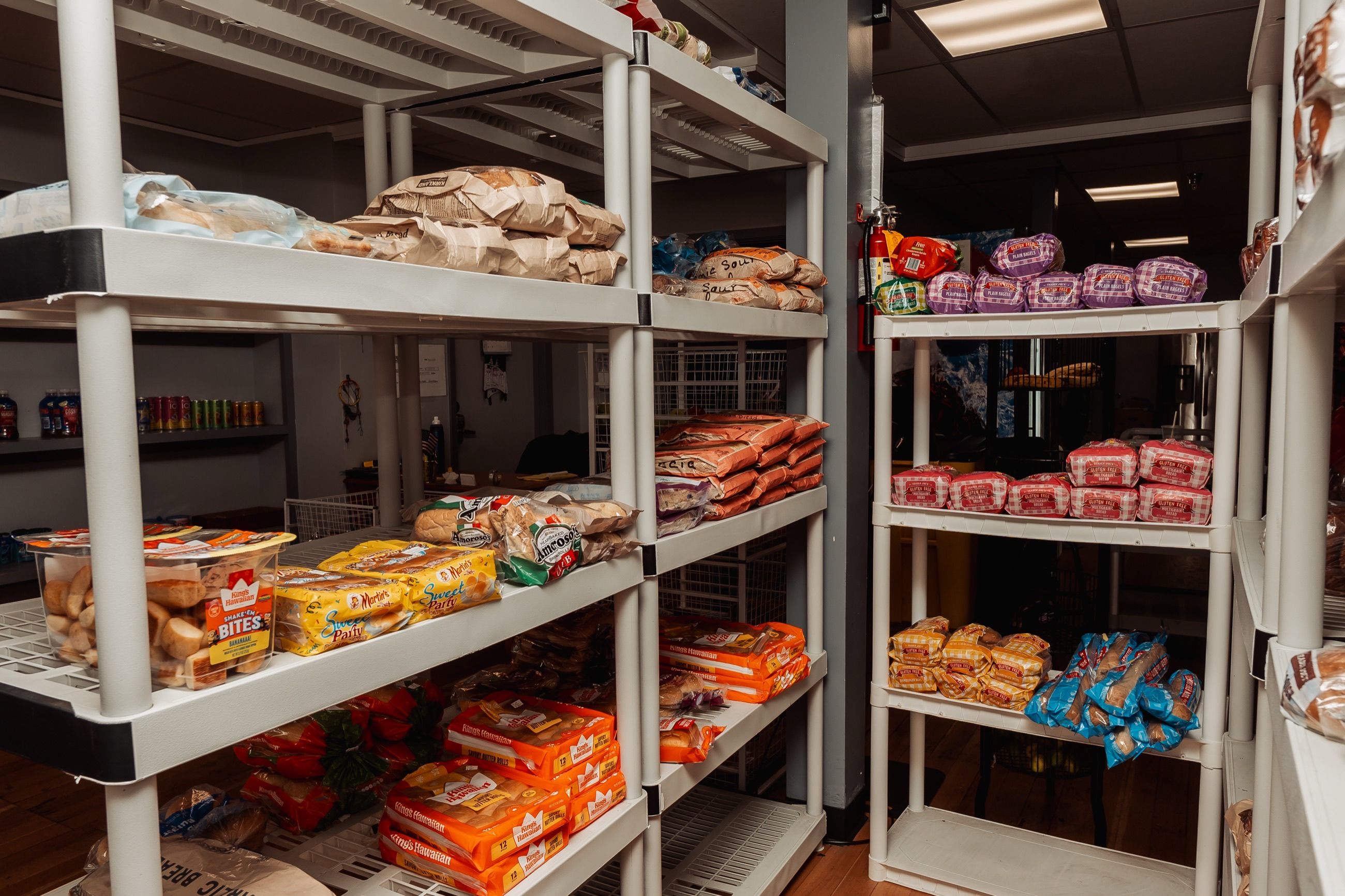 Food pantry shelves stocked with bread, rolls, and gluten-free loaves