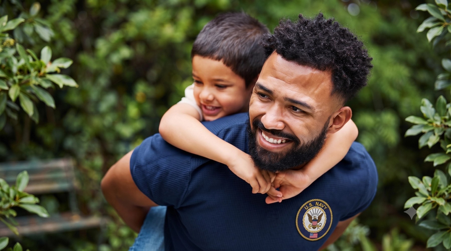 A U.S. Navy Veteran carrying his son on his back, both smiling