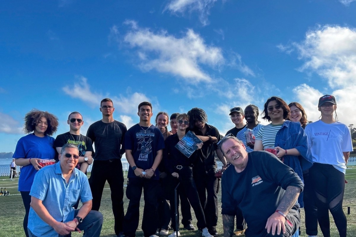 A group of volunteers gathered on a grass field at a community event above Monterey Bay