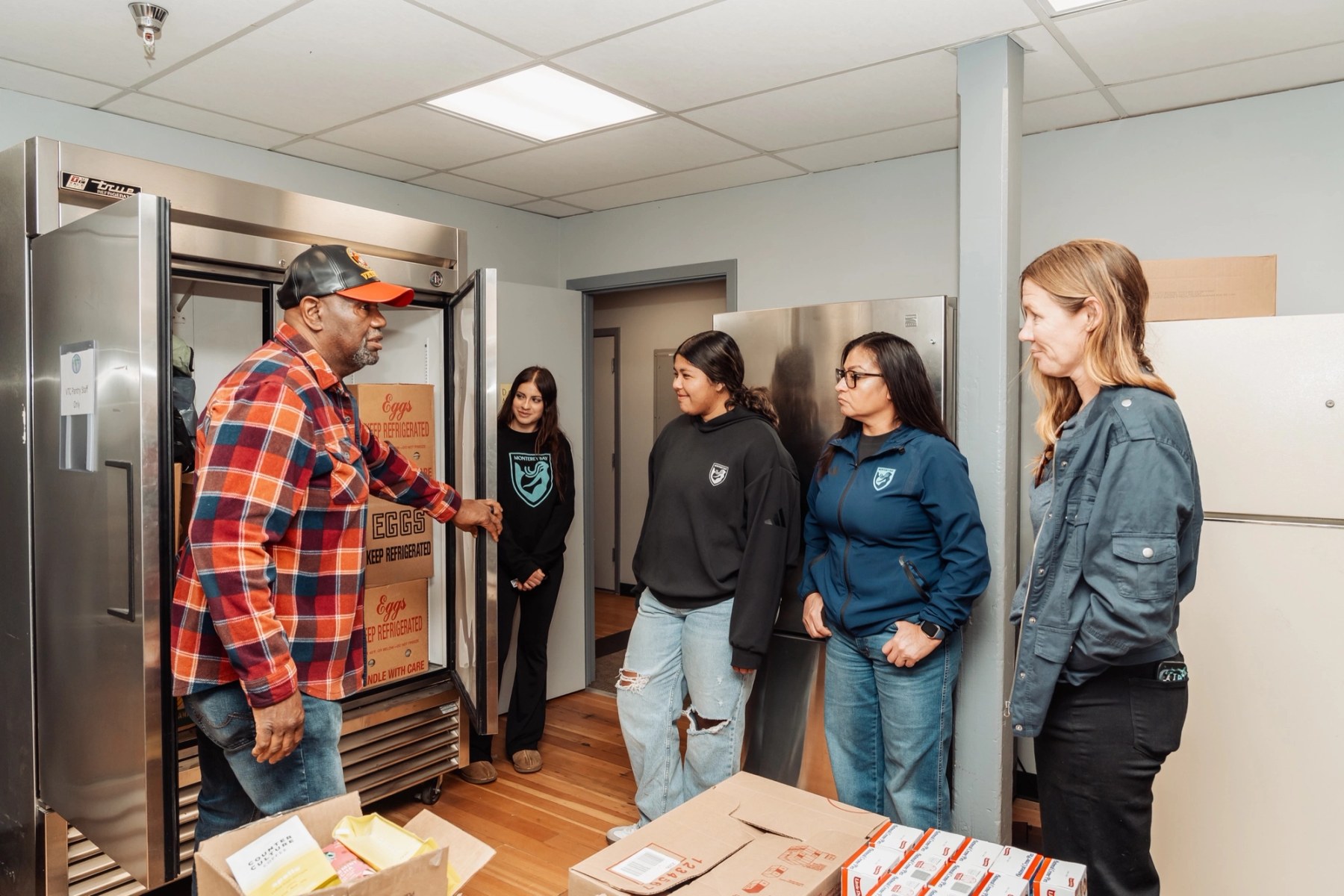 A pantry tour — VTC staff show visitors the food pantry refrigerators and freezers