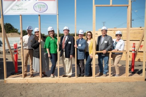 Community members at the Lightfighter Village wall raising