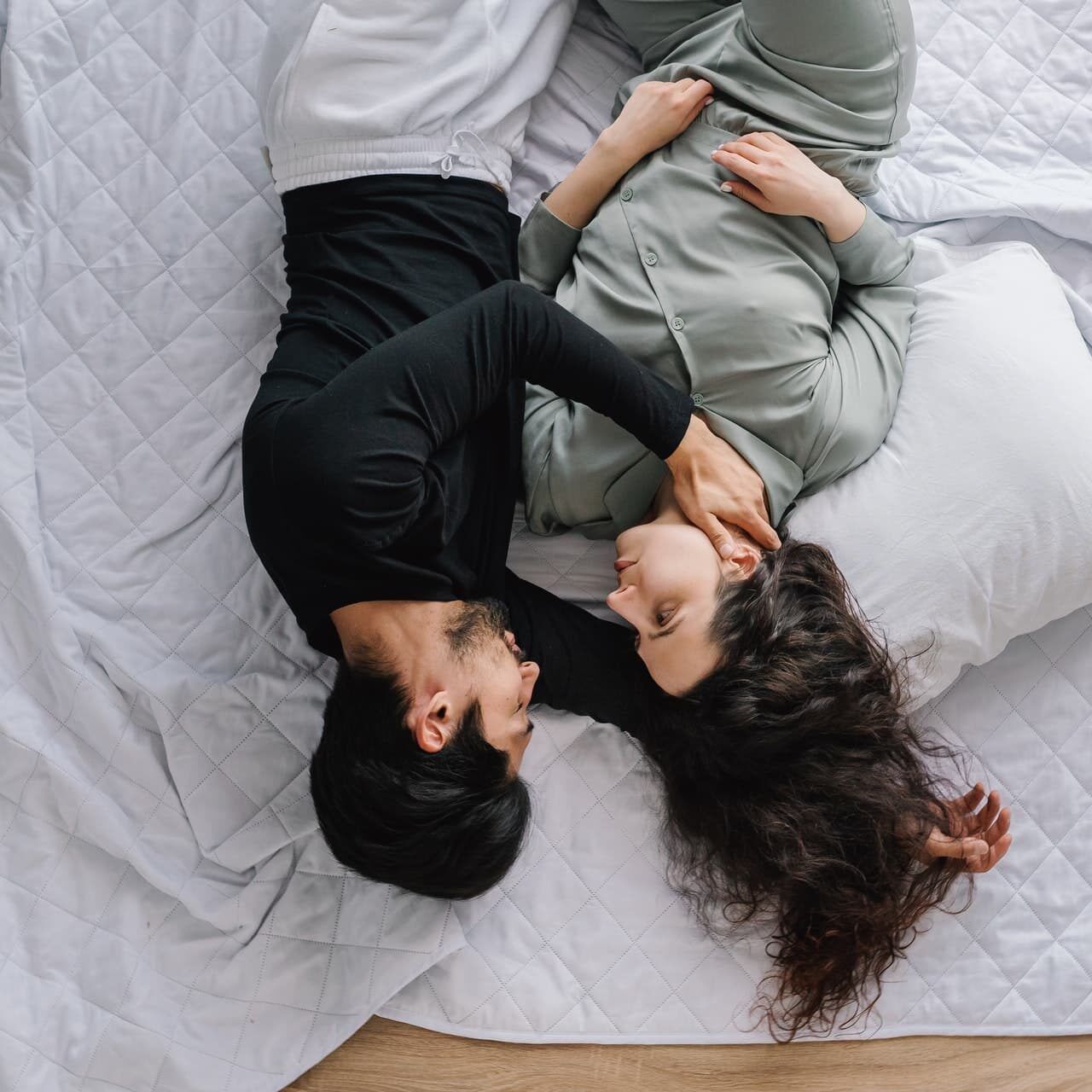 Photo of loving couple laying down on a bed