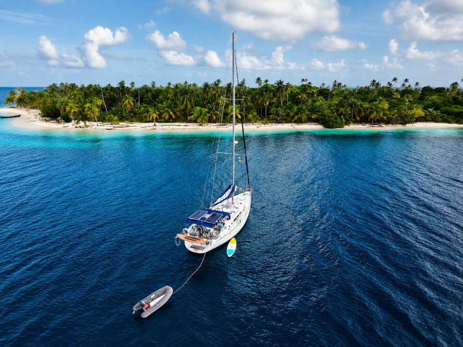 Velero solstice con una isla detrás