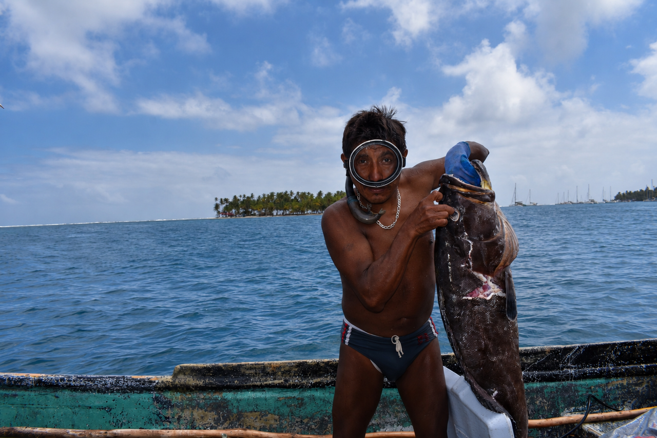 Guna posando con pescado