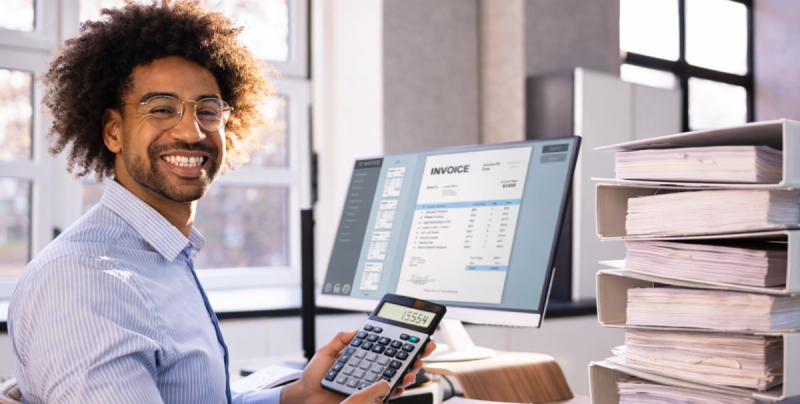 Buchhalter an einem Schreibtisch, Taschenrechner, Ordner