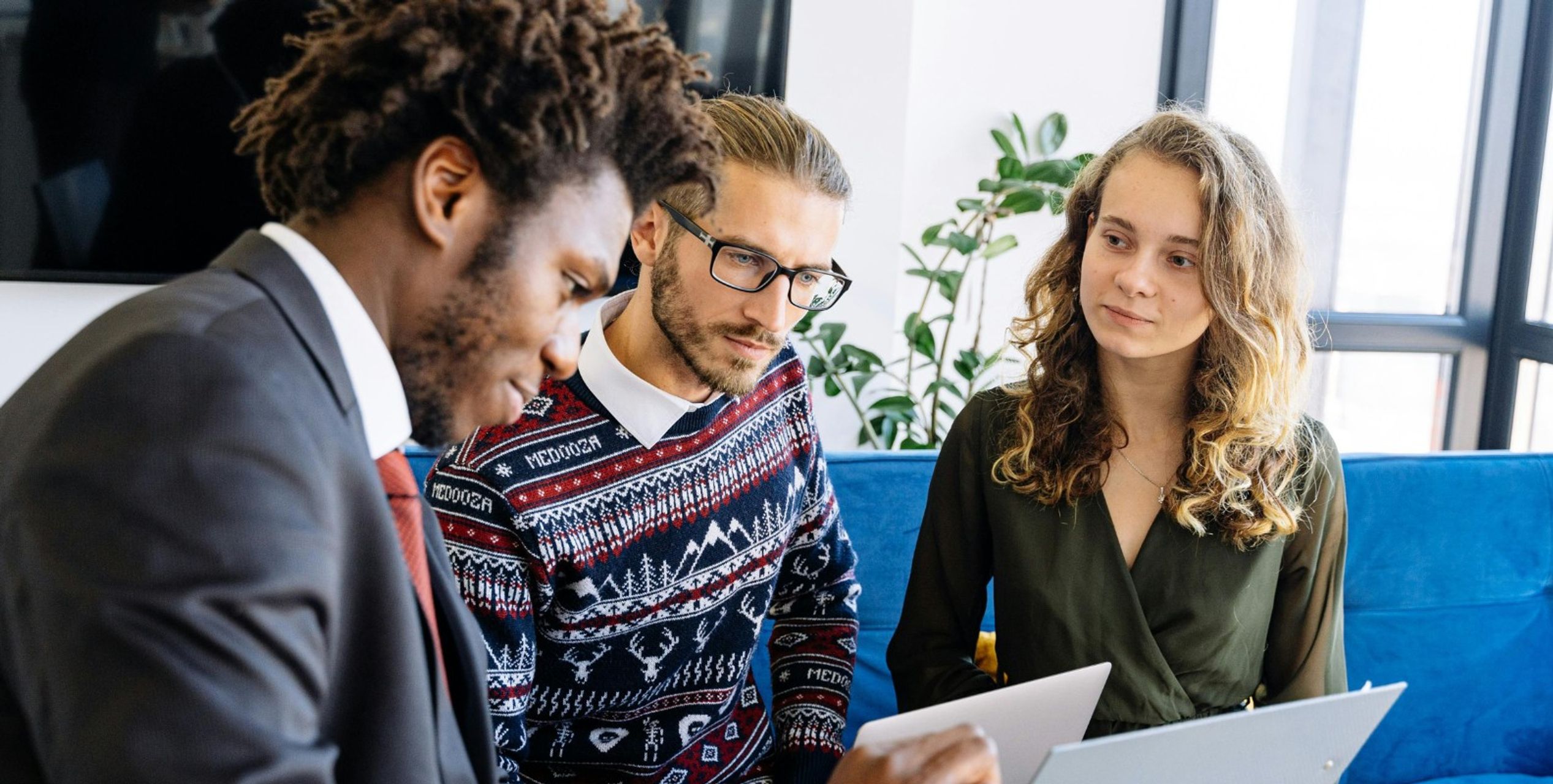 Eine Frau und ein Mann beraten sich mit einem Versicherungsvertreter.
