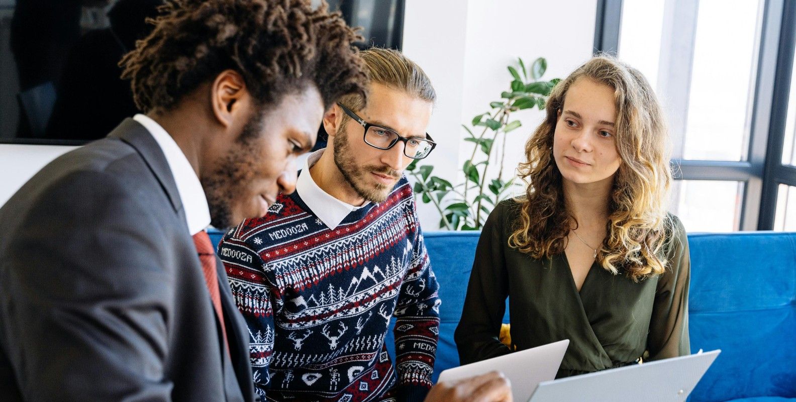 Eine Frau und ein Mann beraten sich mit einem Versicherungsvertreter.