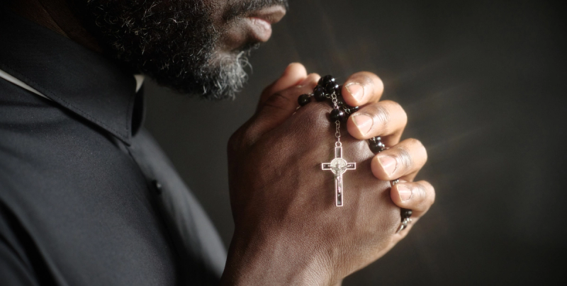 Pfarrer mit Kreuz in den Händen