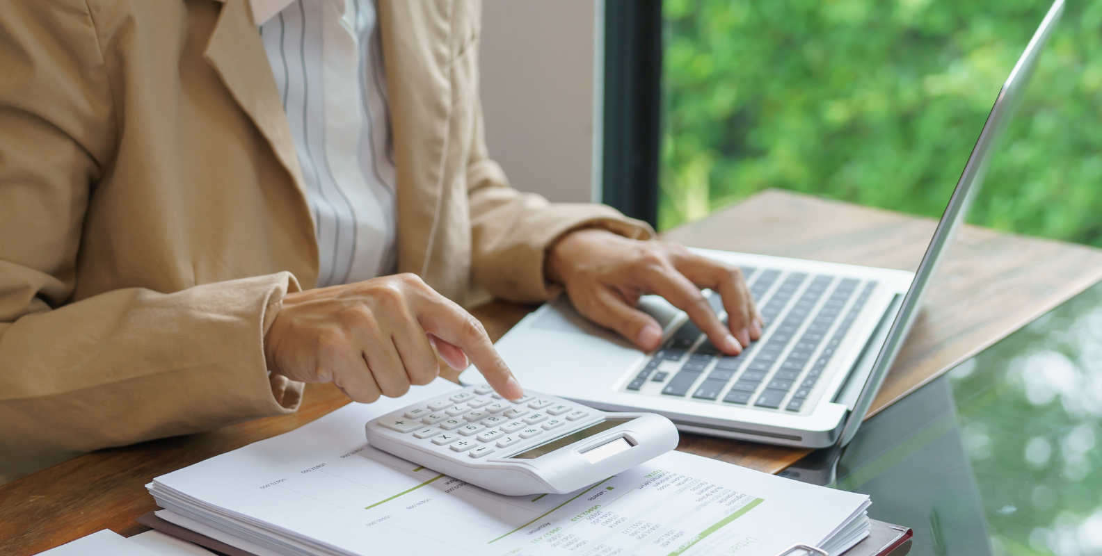 Eine Frau sitzt an einem Laptop mit Taschenrechner