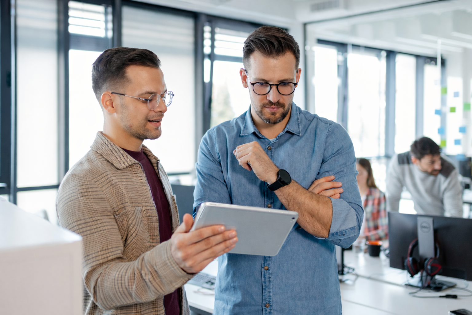Ein Mann zeigt einem anderen Mann etwas auf einem Tablet