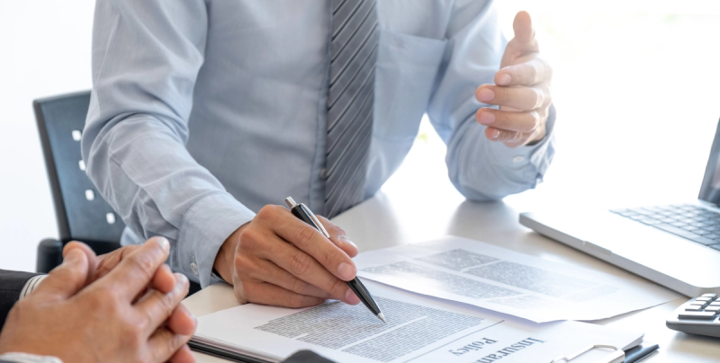 Zwei Männer an einem Tisch, die einen Vertrag unterschreiben