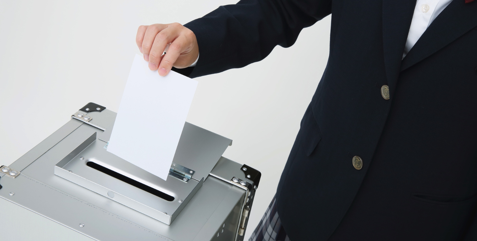 Wahlen, ein Mann wirft einen Stimmzettel ein.