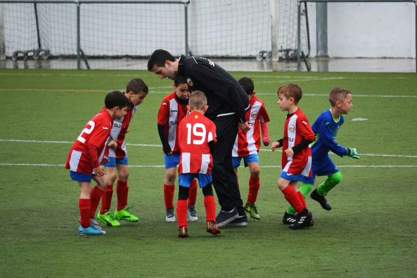 Fußballteam mit Trainer auf dem Spielfeld