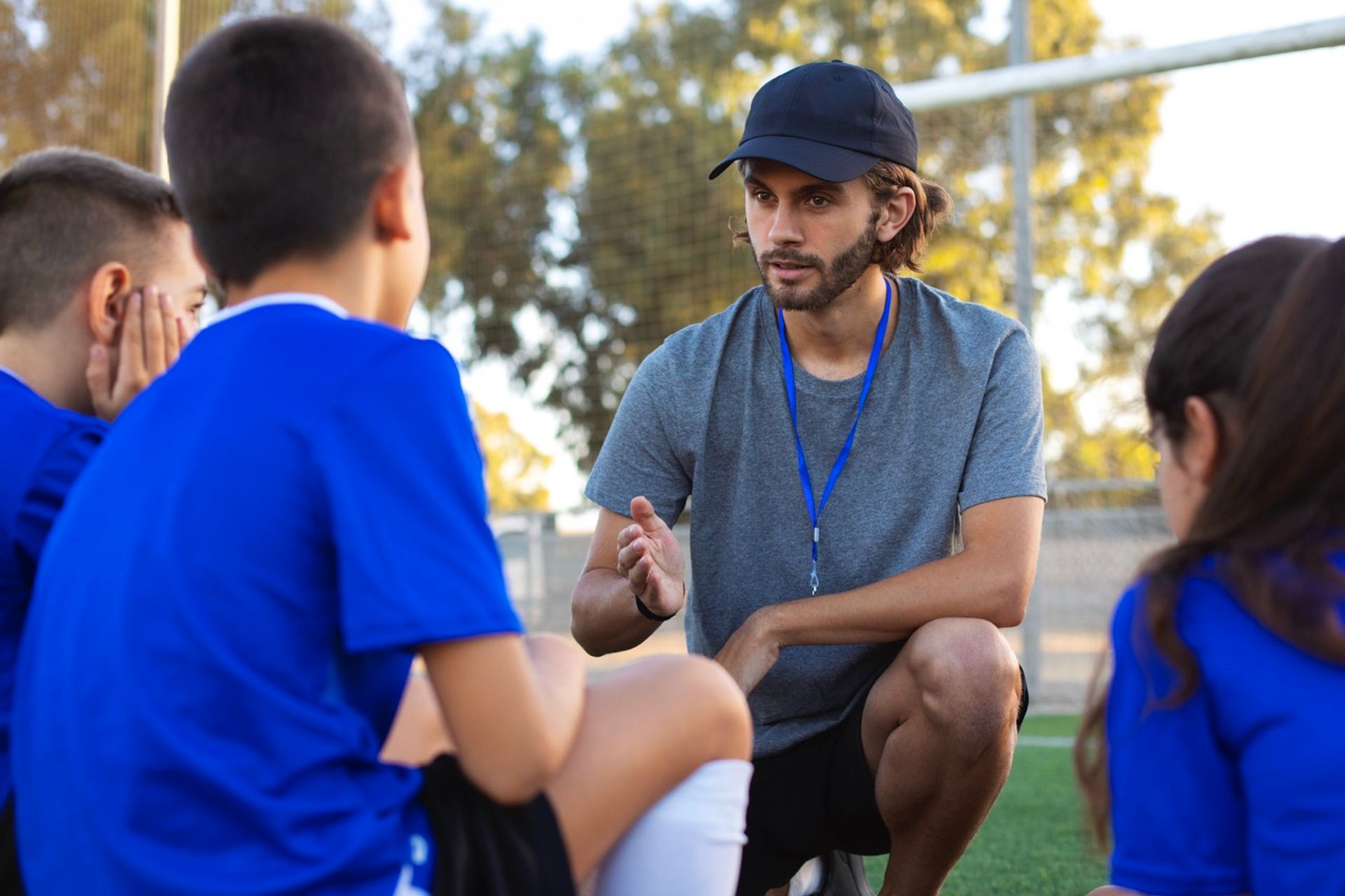 Fußballtrainer unterstützt Kinder beim Training